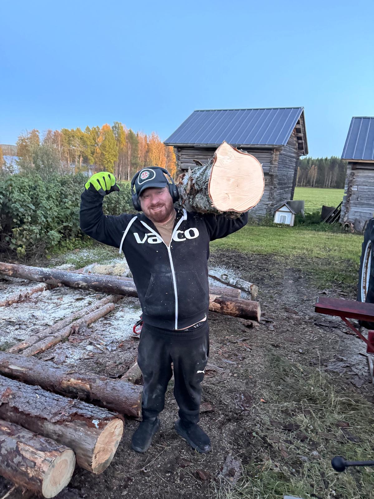 Vanha traktori tukkikuorman kanssa työmaalla